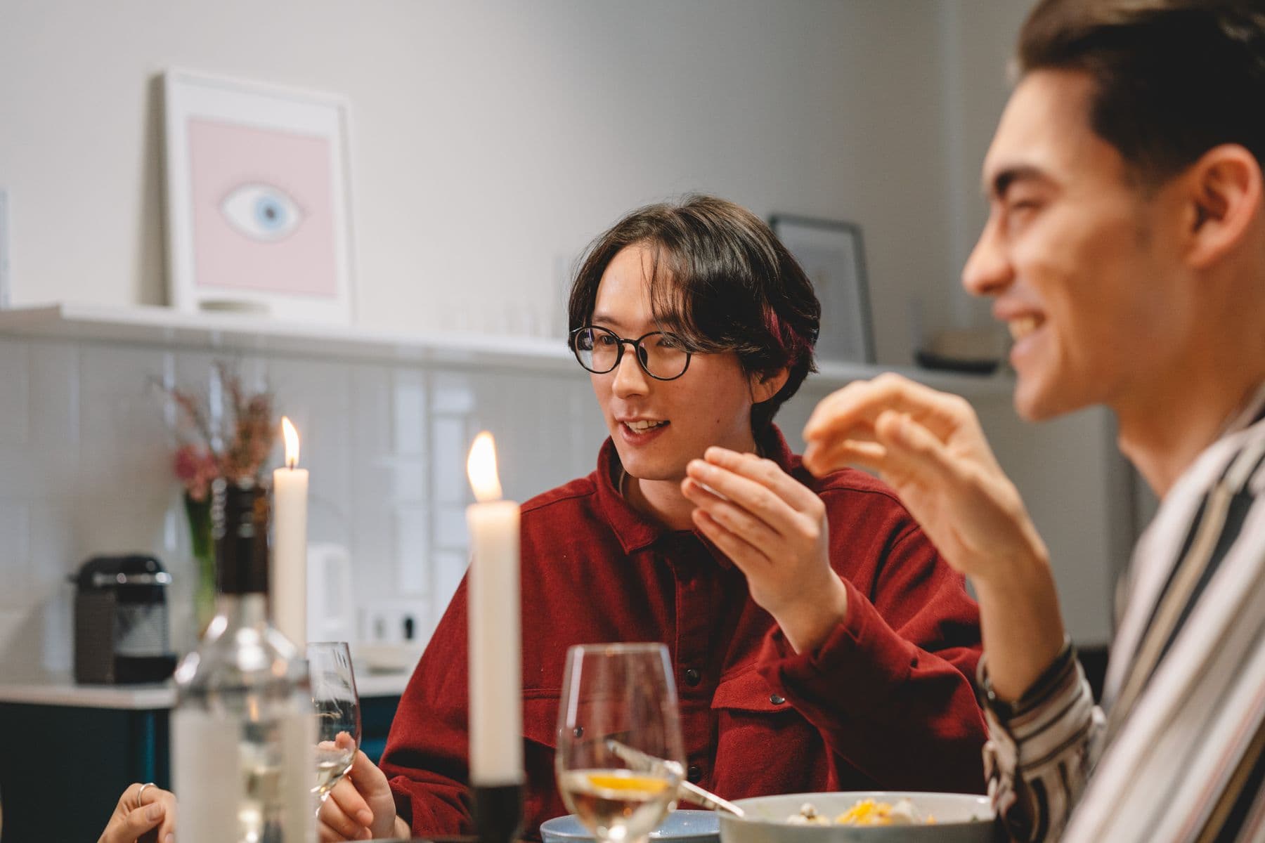 Friends talking over dinner at an apartment table