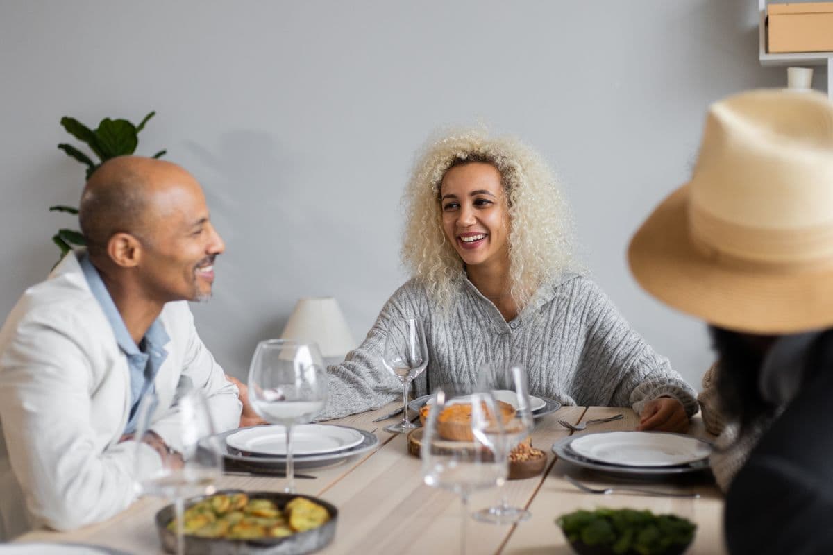 Friends laughing together over dinner at home